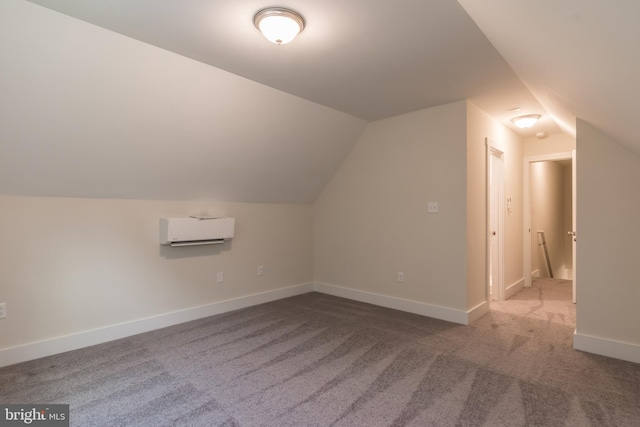 additional living space with carpet flooring, vaulted ceiling, and a wall unit AC