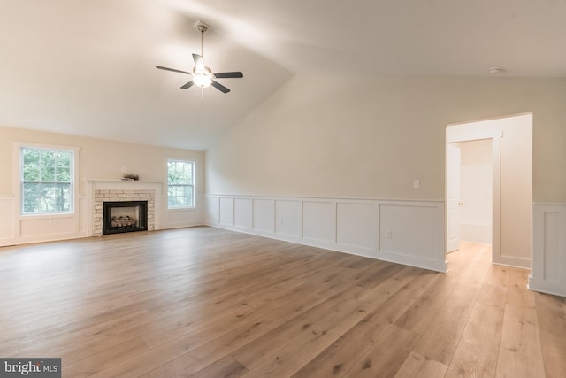 unfurnished living room featuring light hardwood / wood-style floors, vaulted ceiling, and plenty of natural light