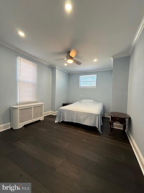 bedroom featuring radiator heating unit, dark hardwood / wood-style floors, ceiling fan, and ornamental molding