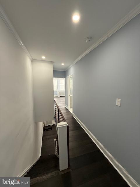 stairs featuring wood-type flooring and ornamental molding