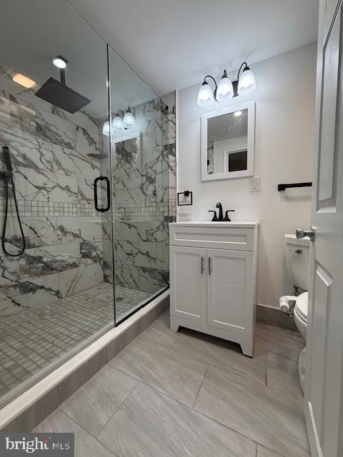 bathroom featuring vanity, toilet, and walk in shower