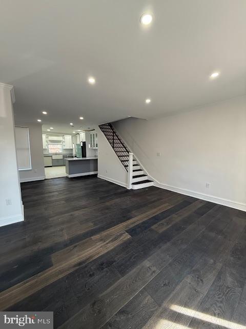 unfurnished living room featuring dark wood-type flooring