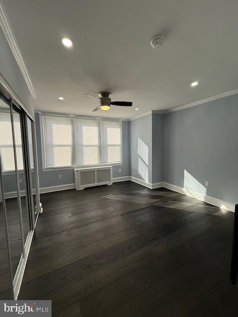 spare room featuring dark hardwood / wood-style floors, ceiling fan, and crown molding