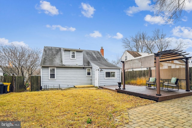 back of house with a pergola, a wooden deck, and a lawn