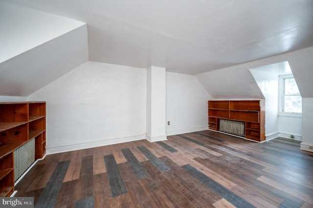 additional living space featuring lofted ceiling, dark wood-type flooring, and baseboards