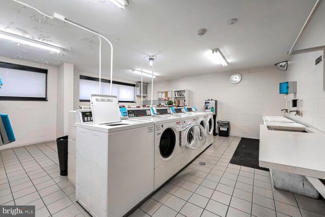 laundry area featuring light tile patterned floors and washing machine and dryer