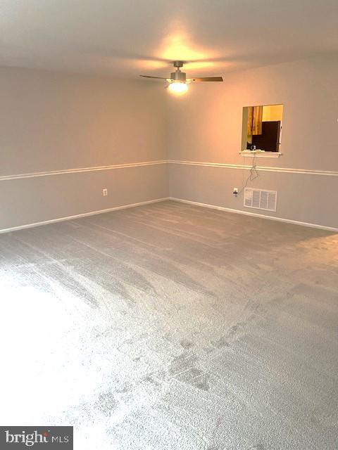 unfurnished room with carpet flooring and ceiling fan