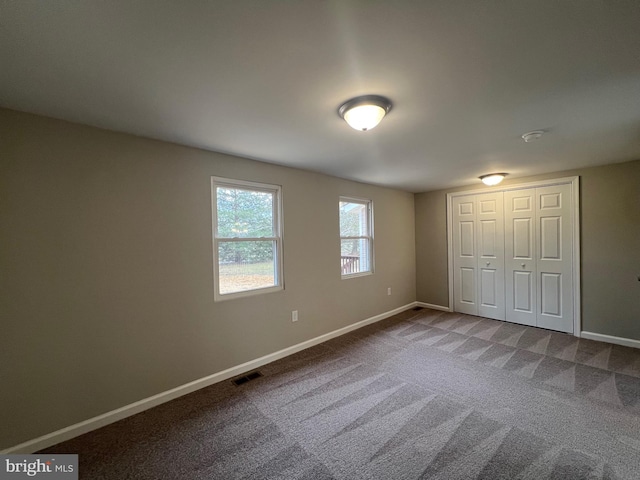 unfurnished bedroom with carpet and a closet