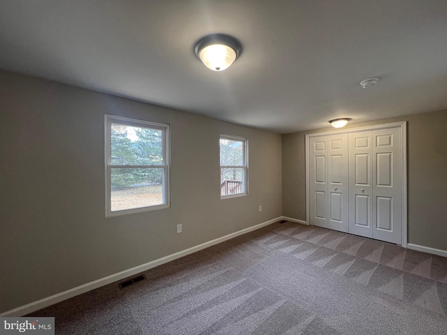 unfurnished bedroom featuring carpet and a closet