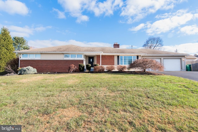 ranch-style house with a garage and a front lawn