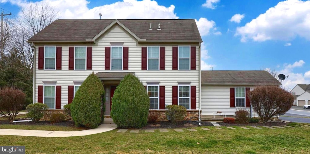 colonial home with a front lawn