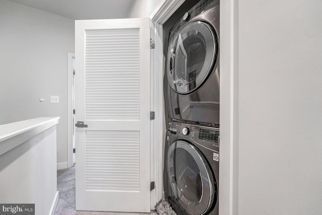 washroom featuring stacked washer and dryer and light colored carpet