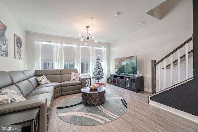 living room with light wood-type flooring and a notable chandelier