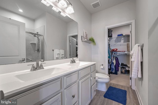 bathroom with vanity, hardwood / wood-style flooring, toilet, and walk in shower