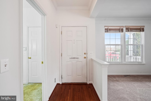 entryway with ornamental molding and dark colored carpet