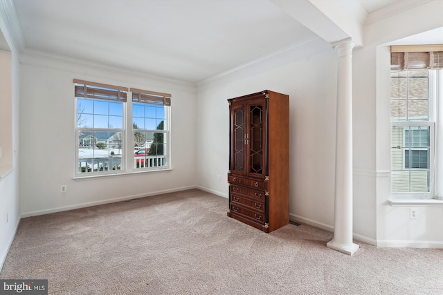 carpeted spare room featuring ornamental molding and ornate columns