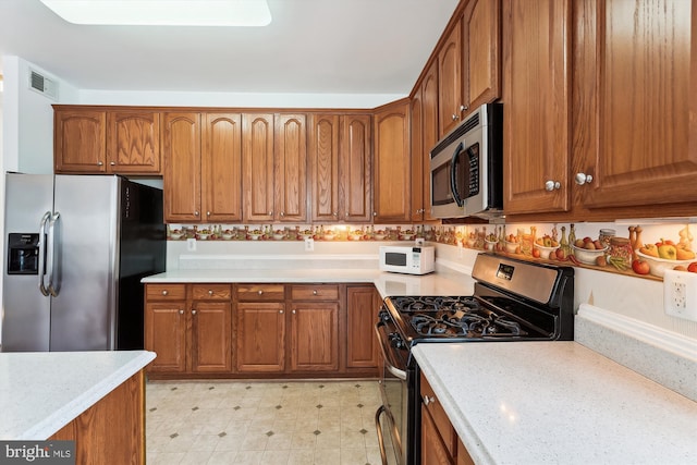 kitchen featuring appliances with stainless steel finishes and light stone countertops