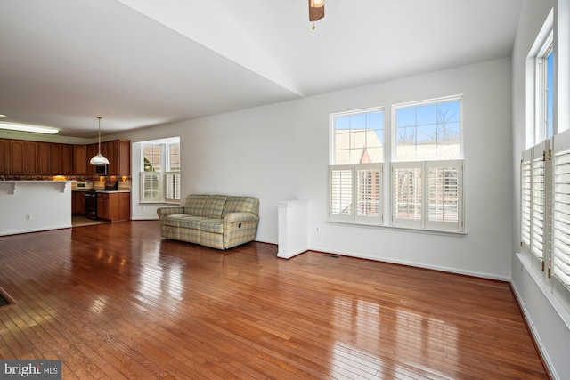 unfurnished living room with ceiling fan, lofted ceiling, and hardwood / wood-style floors