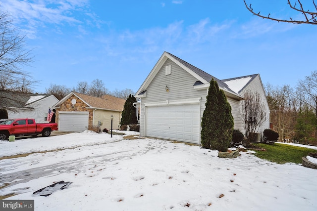 snow covered property with a garage