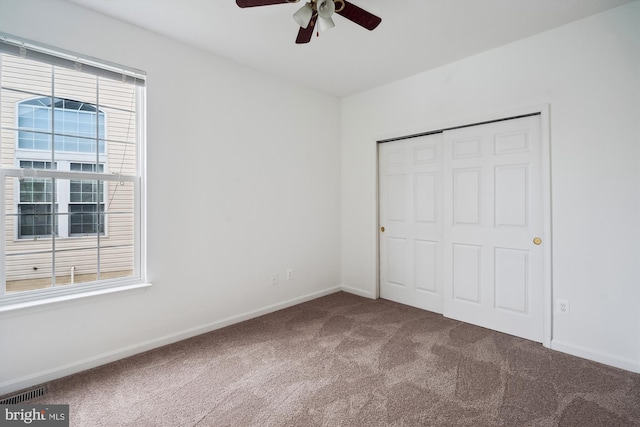 unfurnished bedroom with ceiling fan, carpet, and a closet