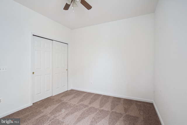 unfurnished bedroom with ceiling fan, a closet, and carpet floors