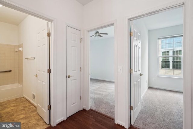 hall with dark colored carpet