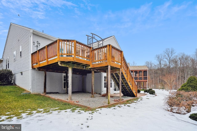 snow covered house featuring a deck, a sunroom, and a lawn