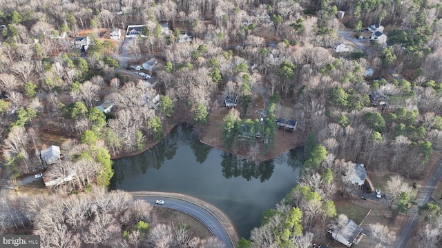 drone / aerial view featuring a wooded view and a water view