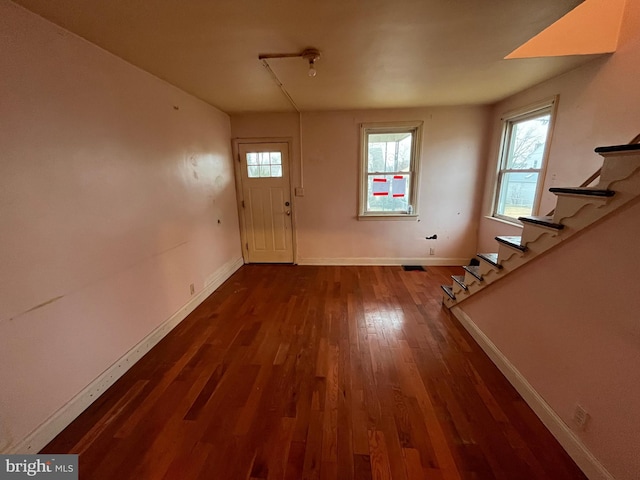 foyer entrance with a healthy amount of sunlight and dark hardwood / wood-style flooring