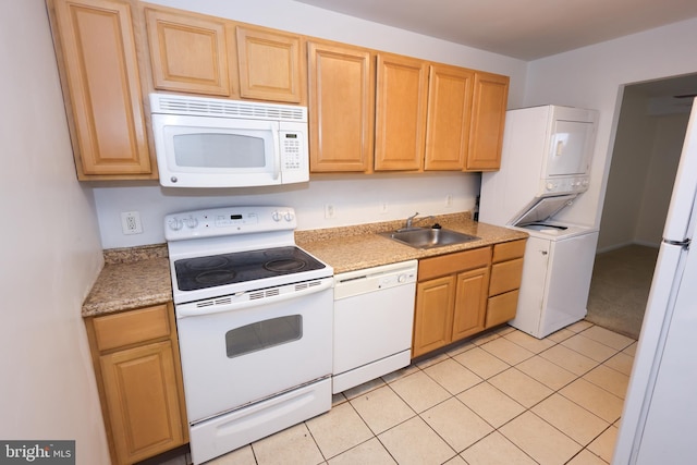 kitchen with stacked washer and clothes dryer, sink, light tile patterned floors, and white appliances