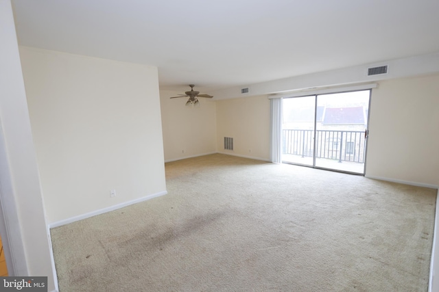 carpeted spare room featuring ceiling fan