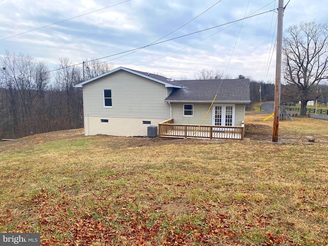 rear view of property featuring a lawn and a deck