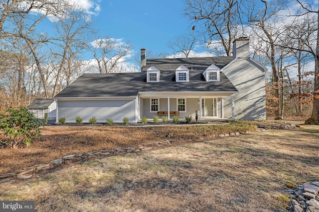 cape cod house featuring covered porch and a front yard