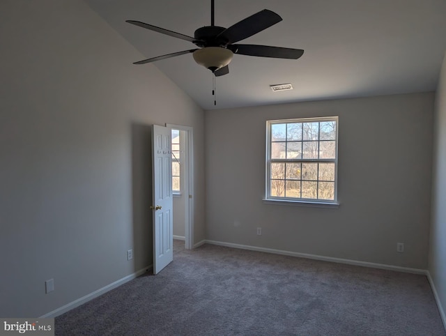 spare room featuring visible vents, a ceiling fan, carpet flooring, vaulted ceiling, and baseboards