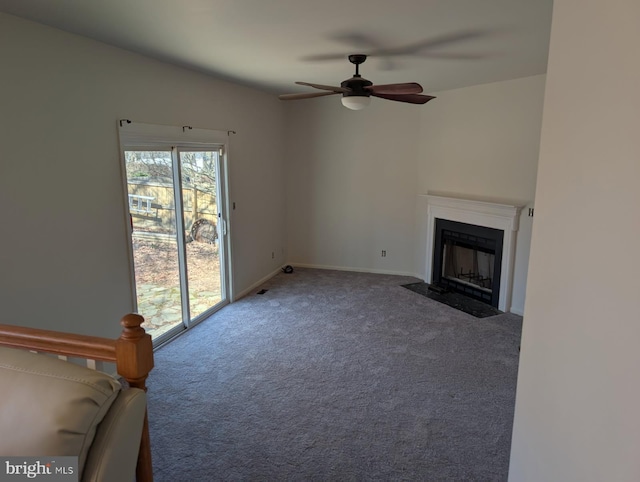 unfurnished living room featuring a fireplace with flush hearth, carpet, and a ceiling fan