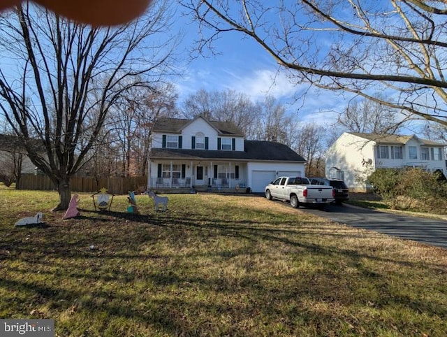 view of front of house featuring covered porch, a garage, fence, driveway, and a front yard