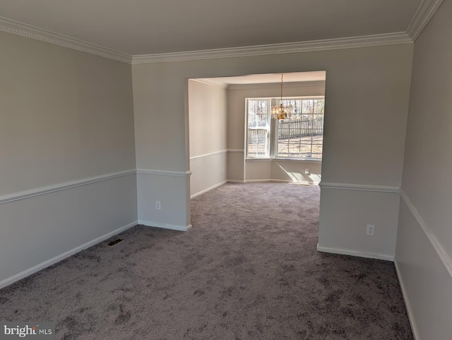 carpeted empty room featuring a notable chandelier, crown molding, and baseboards