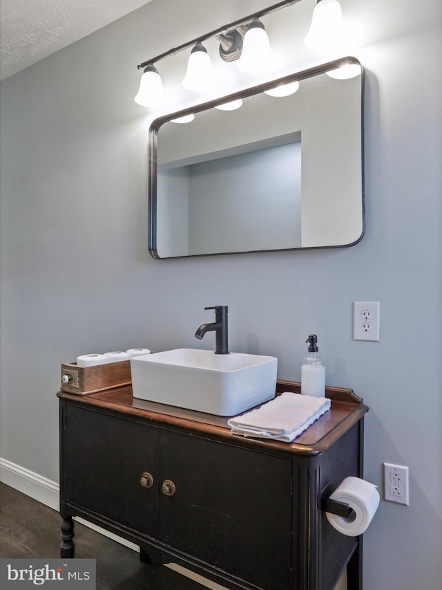 bathroom featuring hardwood / wood-style flooring, vanity, and a textured ceiling