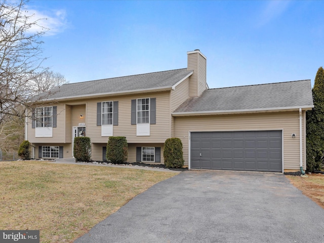 raised ranch with a garage and a front yard