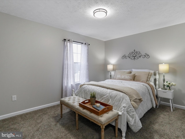 bedroom featuring a textured ceiling and dark carpet