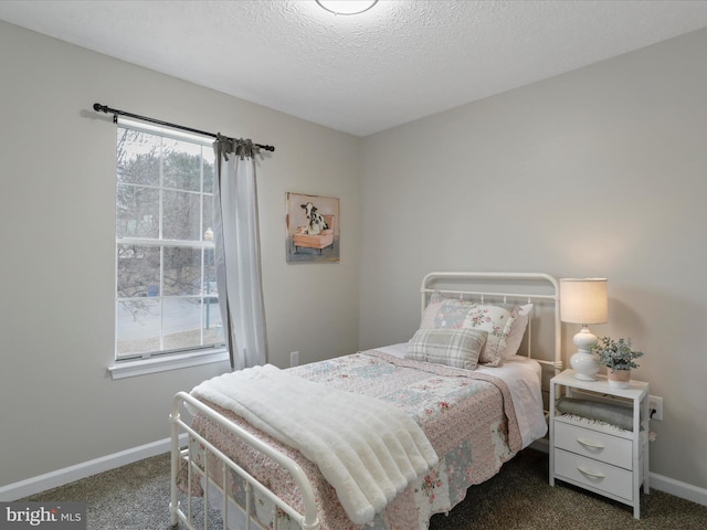 bedroom with dark carpet and a textured ceiling