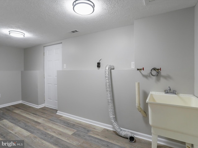 bathroom with sink, hardwood / wood-style floors, and a textured ceiling