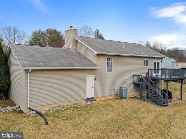 rear view of property featuring a wooden deck, a yard, and cooling unit