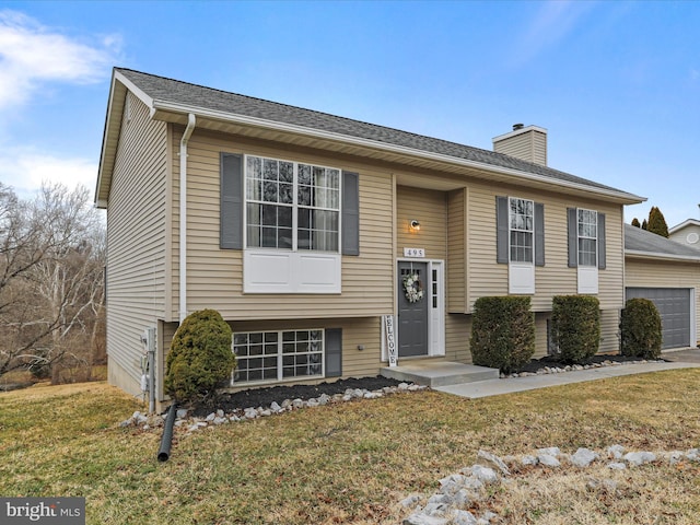 split foyer home featuring a garage and a front lawn