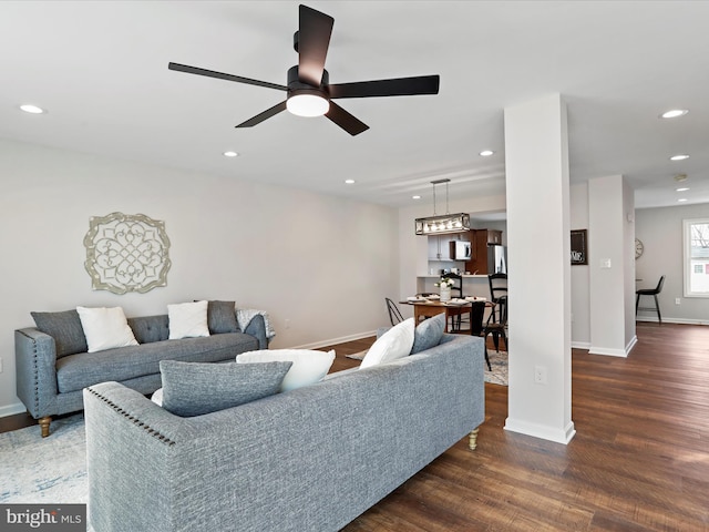 living room featuring ceiling fan and dark hardwood / wood-style flooring