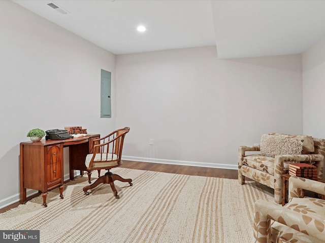 home office with hardwood / wood-style floors and electric panel