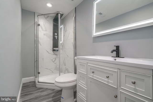 bathroom featuring hardwood / wood-style floors, vanity, toilet, and an enclosed shower