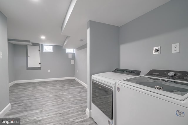 washroom with washer and dryer and light hardwood / wood-style floors