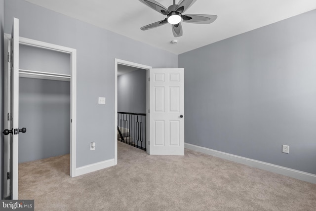 unfurnished bedroom with ceiling fan, light carpet, and a closet