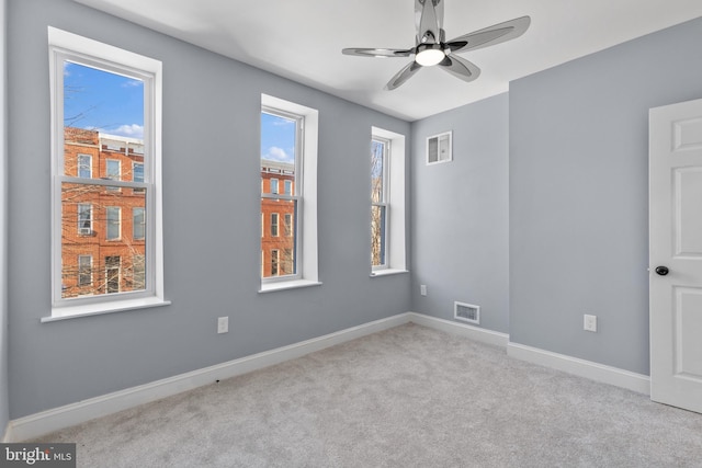 carpeted spare room featuring ceiling fan